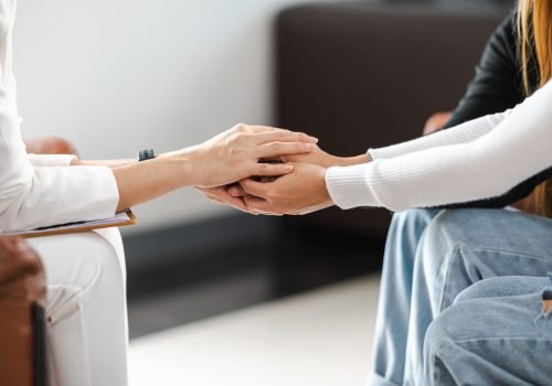 Psychologist holding hands and provide assistance understanding problems of a woman patient Psychologist holding hands and provide assistance understanding problems of a woman patient